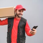 Young delivery man checking adress of costumer with scanner